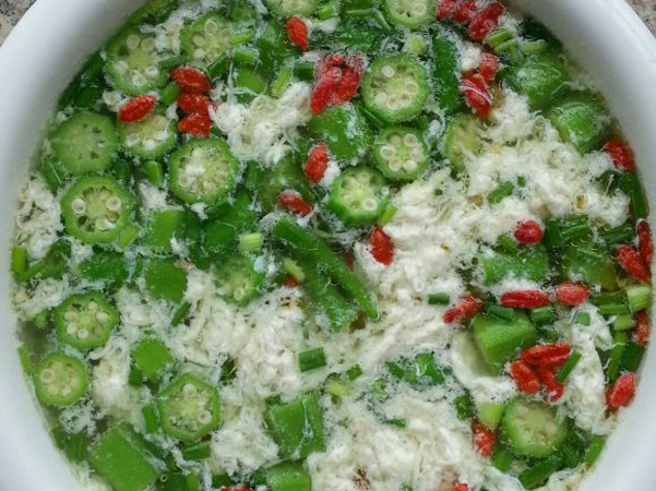 取瘦猪肉切片,放油锅中爆炒,随即加入黄秋葵花,旺火速炒,加入调料,起